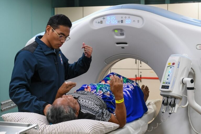 dosis de radiación en estudios de imagen — Medical professional assists patient during ct scan procedure